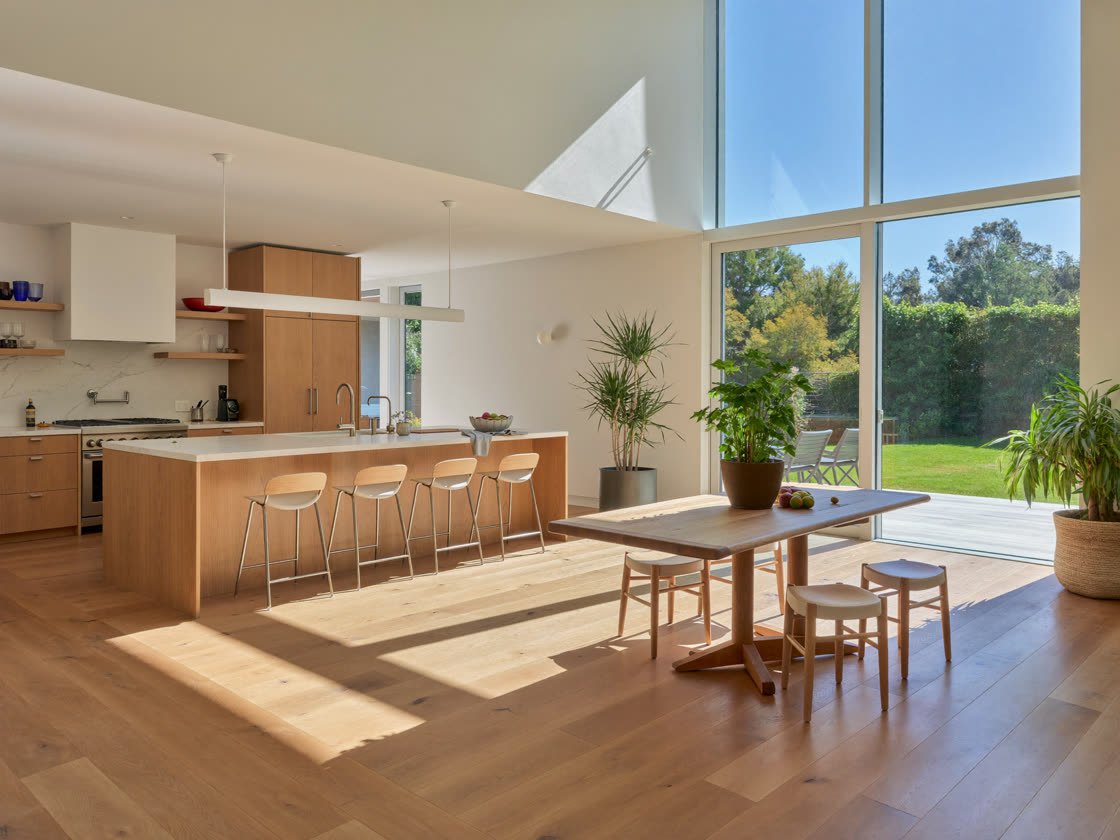 Bright open kitchen and dining area with a large island, garden-view windows and daylight